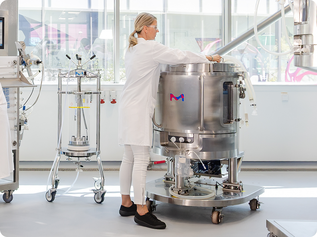 Scientist in front of single-use mixer Scientist in front of single-use mixer.