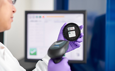 A laboratory technician using a barcode scanner on a sample container, showcasing digital data management and automated recordkeeping for improved accuracy and audit-ready reporting. A laboratory technician using a barcode scanner on a sample container, showcasing digital data management and automated recordkeeping for improved accuracy and audit-ready reporting.