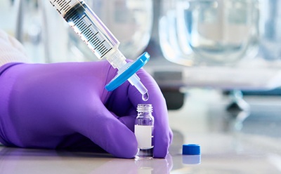 <p>More Success in LC-MS</p>
Photograph of gloved hand using a Millex® hydrophilic PTFE syringe filter to filter sample into a vial.