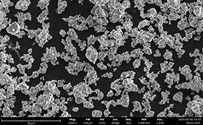 A scanning electron microscope (SEM) image displaying dense thin films of solid electrolytes processed with specific materials (PHE-15 micro LATP). The image reveals a textured surface with various particle shapes and sizes, illustrating the intricate structure of the films against a dark background. A scanning electron microscope (SEM) image displaying dense thin films of solid electrolytes processed with specific materials (PHE-15 micro LATP). The image reveals a textured surface with various particle shapes and sizes, illustrating the intricate structure of the films against a dark background.