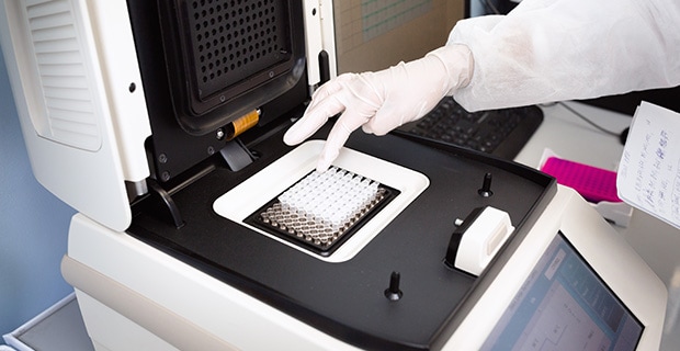 Raw Materials for Molecular Diagnostics DNA being placed into the PCR thermal cycler or amplifier for PCR diagnostics.