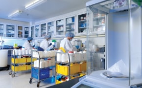 Process Development Scientists in an Upstream Lab A photo showing three process development scientists seating at a bench in a lab to do formulation reviews and feasibility assessments for cell culture media.