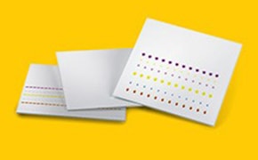 Thin Layer Chromatography (TLC) A stack of white punch cards set against a vivid yellow backdrop. One card is prominently displayed in front, showcasing a pattern created by an array of holes punched at various positions.