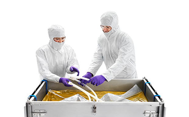 Mobius® 3D single-use assemblies Two technicians in a sterile environment are operating a Mobius 2D and 3D single-use assembly system. They are dressed in full protective cleanroom suits, complete with hoods and masks, ensuring a contamination-free process.
