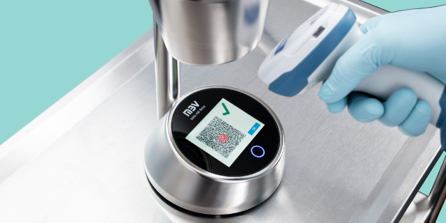<p>Getting Equipped for the Future</p>
Blue-gloved hand scans a QR code on a stainless-steel laboratory device using a handheld scanner.