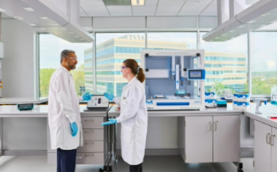 2 scientists interpreting data on a laptop next to the AAW™ workstation