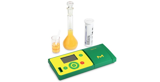 RQflex® 20 Reflectometer The portable RQFlex® 20 reflectometer with test strips, a beaker and a bottle.