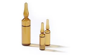 The image depicts three amber glass ampoules of varying sizes, arranged in descending order from left to right on a white surface, commonly used for storing liquid medications or vaccines.