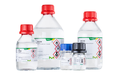 Group of PFAS analysis solvents Assorted PFAS-tested solvents in clear bottles with red caps and hazard labels arranged together.