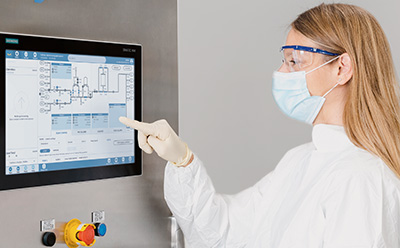 Scientist at a CoPrime Biochromatography unit operation using the HMI to interact with CCP® control software to adjust the system's parameters.