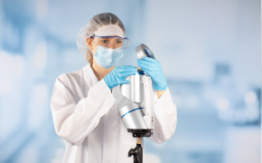 MAS-100<sup>®</sup> Series Air Samplers Large, brown solvent bottle with Supelco® branded label is opened by a lab worker wearing blue nitrile gloves. Only the hands and lower arms of the worker are shown. One small brown solvent bottle and two small white bottles can be seen in the background.