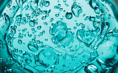 Microscopic view of hydrated hydrogel matrix. Close-up image showing water-filled hydrogel matrix with dispersed droplets and a translucent polymer network.