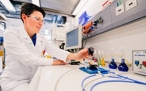 实验室显示器前方的科学家,使用一些试管进行实验 实验室显示器前方的科学家,使用一些试管进行实验