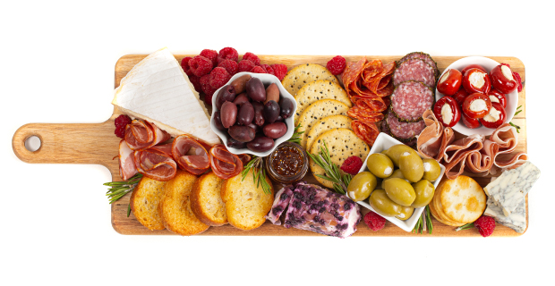 Displayed on a charming wooden board equipped with a convenient handle, the charcuterie platter presents a delightful assortment of savory delicacies. The carefully curated selection includes a variety of preserved meats, enticing olives, flavorful peppers, luscious berries, crisp crackers, and an array of delectable cheeses.