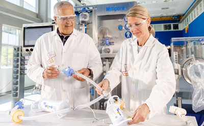 Preparing Single-Use Assemblies for Aseptic Processing Technical specialists preparing single-use assemblies with tubing and connectors in an aseptic processing environment.