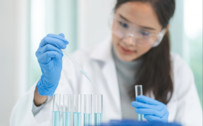 Laboratory scientist preparing water samples Female scientist holding a test tube and pipette with water samples in glassware on a lab bench