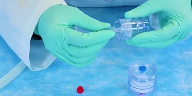 <p>Millipore<sup>®</sup> 环境空气监测用气溶胶监测仪</p> In the lab setting, a person with blue gloves is testing