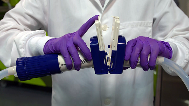 Lynx CDR Demo Video Poster A person in a lab coat and gloves adjusting a device in a laboratory setting.