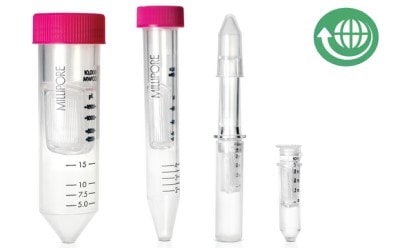 A set of laboratory tubes and a pipette, including two larger tubes with pink caps marked with 'M' and a smaller graduated pipette, all arranged on a reflective surface.