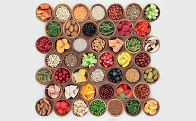 An array of colorful spices and ingredients, each housed in individual round bowls, neatly arranged