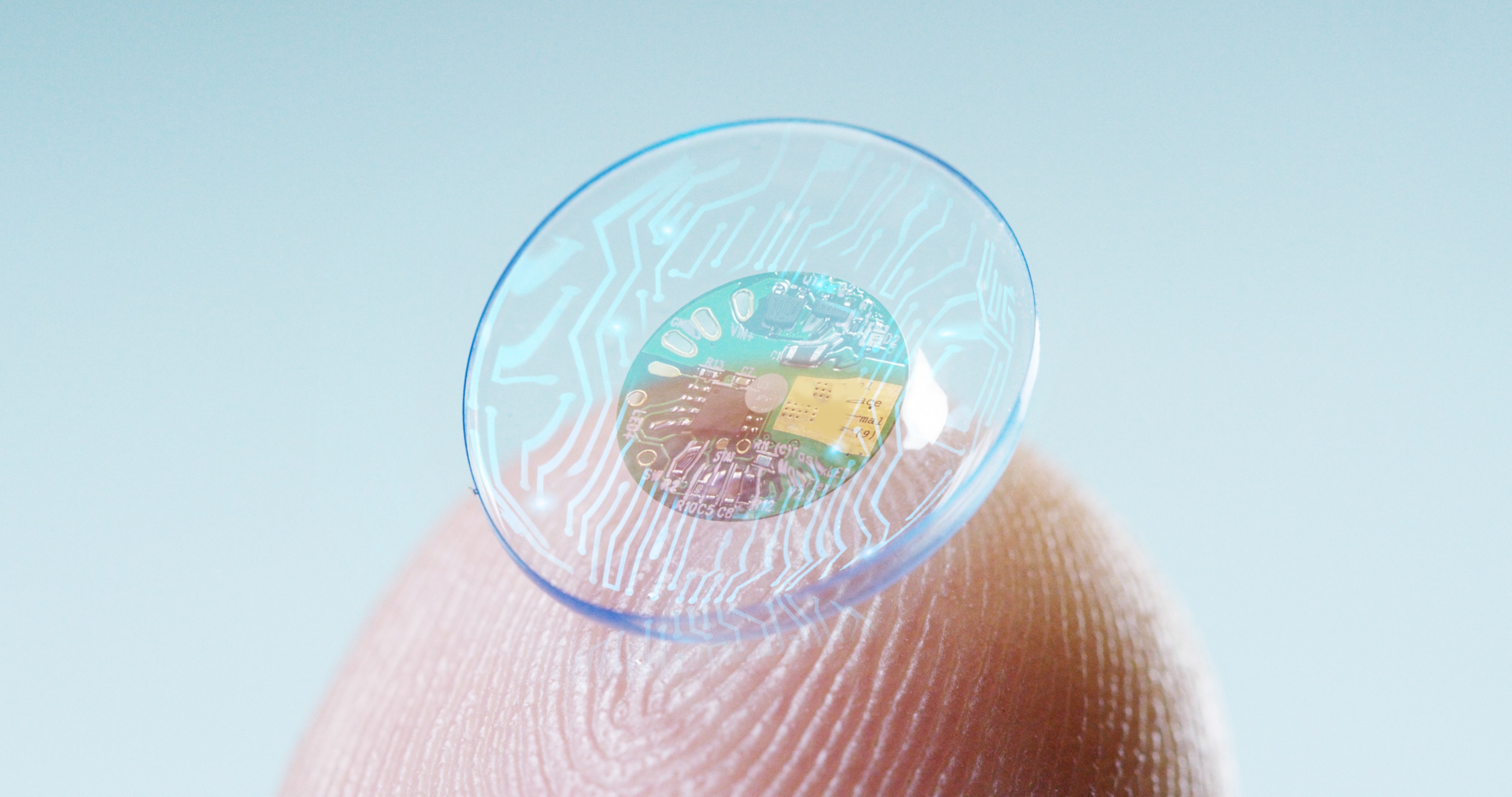 Contact lens with sensor in middle held on fingertip.