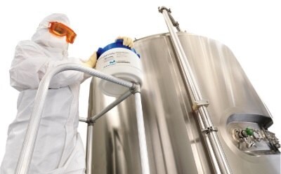 Scientist preparing media fill culture media for aseptic process simulation