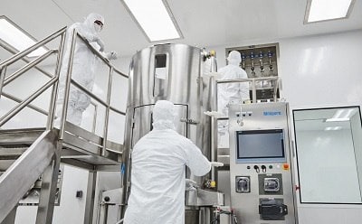 Scientists in white lab suits conducting experiments in a laboratory.