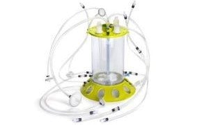 Mobius® iFlex Bioreactor 200 L in perfusion mode. A clear cylinder with a yellow base and top, with clear tubes coming out all around. 