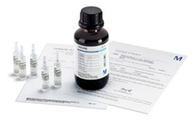 A bottle of TraceCERT® reference material is displayed alongside several small ampoules and certification documents. The bottle has a detailed label with specifications, and the ampoules contain clear liquid. The arrangement suggests high-purity analytical standards for laboratory use. A bottle of TraceCERT® reference material is displayed alongside several small ampoules and certification documents. The bottle has a detailed label with specifications, and the ampoules contain clear liquid. The arrangement suggests high-purity analytical standards for laboratory use.