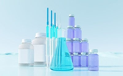 Visual representation of small molecule liquid formulation solutions, featuring laboratory glassware, syringes, and vials with colored liquids, highlighting expertise in liquid dosage forms.