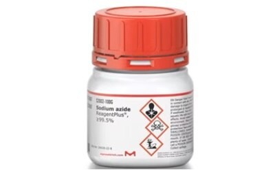 Sodium Azide A white plastic bottle with a red cap labeled “Sodium azide ReagentPlus®, 99.5%”. On the label, there are hazard symbols indicating flammability, an exclamation mark denoting a warning, and a health hazard icon. Below the symbols is a red diamond-shaped label with a fire symbol indicating its flammability and danger if it catches fire. The product code “1006” is visible at the top of the label.