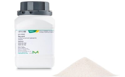 一个白色塑料容器上有一个黑色旋盖，上面标有产品信息，旁边是一小堆白底白色粉末。