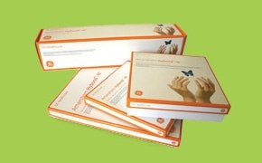 Four boxes of Whatman laboratory supplies including Blotting Papers, Membranes, & FTA Cards against a green background. The products feature an orange and white design and descriptive text on their labels.