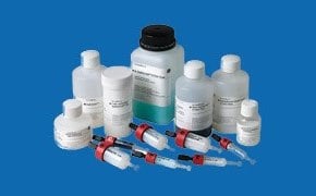 An array of Cytiva™ bioprocess products displayed against a blue background. The collection includes several white plastic bottles with labels and red-capped syringes.