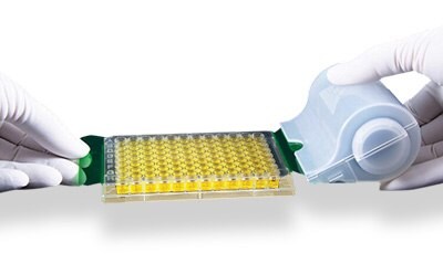 SealMate™ rolls Photograph showing two gloved hands using an adhesive seal on a roller to seal a microplate.