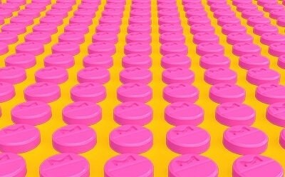 Rows of pink tablets representing a manufacturing environment.