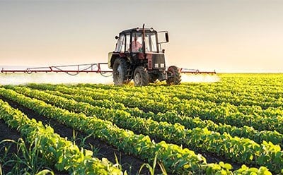Pesticides In this image we can see a tractor over the farm where they are doing a farming procedure.