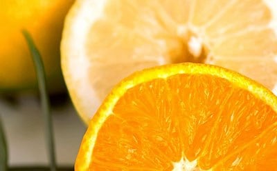 A vibrant close-up of a juicy, sliced orange with a contrasting slice of lemon in the background, highlighting the fresh and appetizing texture of the citrus fruits.