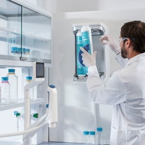 A lab worker changes the purification cartridge on the Milli-Q® IQ water purification system