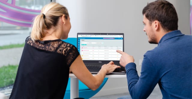 Two scientists in front of a laptop collaborating on Orchestrator to monitor and visualize their bioprocess