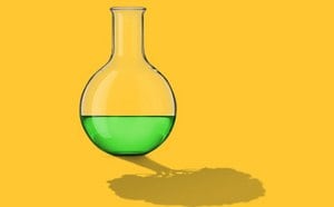 Image shows a flask with green liquid on yellow background, reflection has the shape of a tree