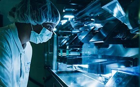 A masked scientist performing quality control