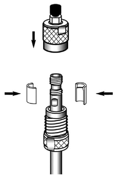  An assembly process where two components are being connected. The top part is a cylindrical piece that attaches to a lower component, which is a threaded fitting connected to tubing. Two half-circle clips are inserted from the sides into a groove on the threaded fitting to ensure a secure connection between the parts. An arrow indicates the top part should be attached by pushing it downward onto the threaded fitting, allowing for a firm, reliable connection for fluid transfer. This assembly does not require an additional precolumn.