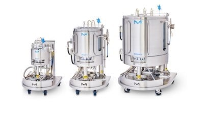 Three Mobius Single-Use Bioreactors (10 L, 100 L, 500 L) aligned next to each other. Each bioreactor consists of a cylindrical vessel with multiple ports and tubes attached, mounted on a wheeled support structure for mobility.